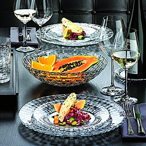 Dining table setting with plates, fruit, and wine glasses.