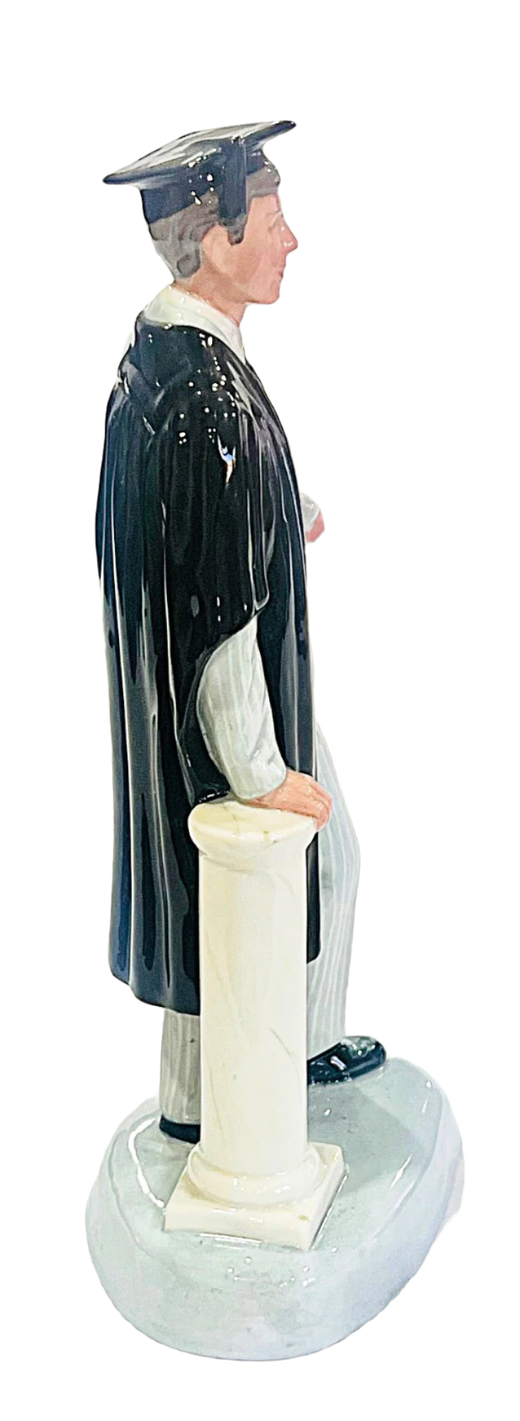 Statue of a person in academic gown and cap on a white background
