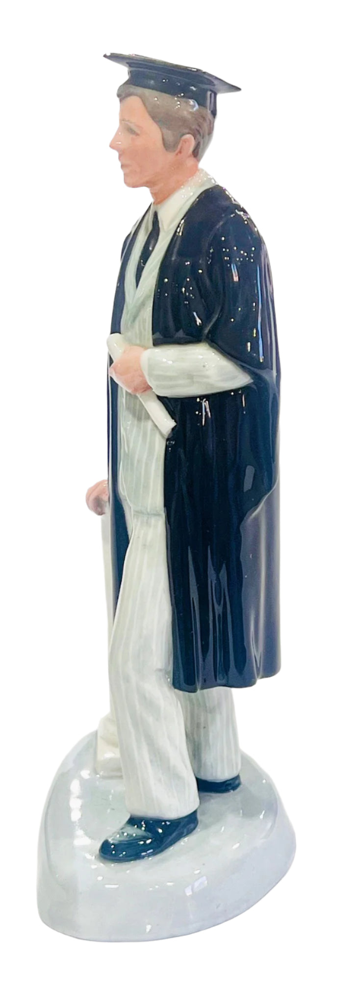 Graduation figurine in black gown and cap on a white background