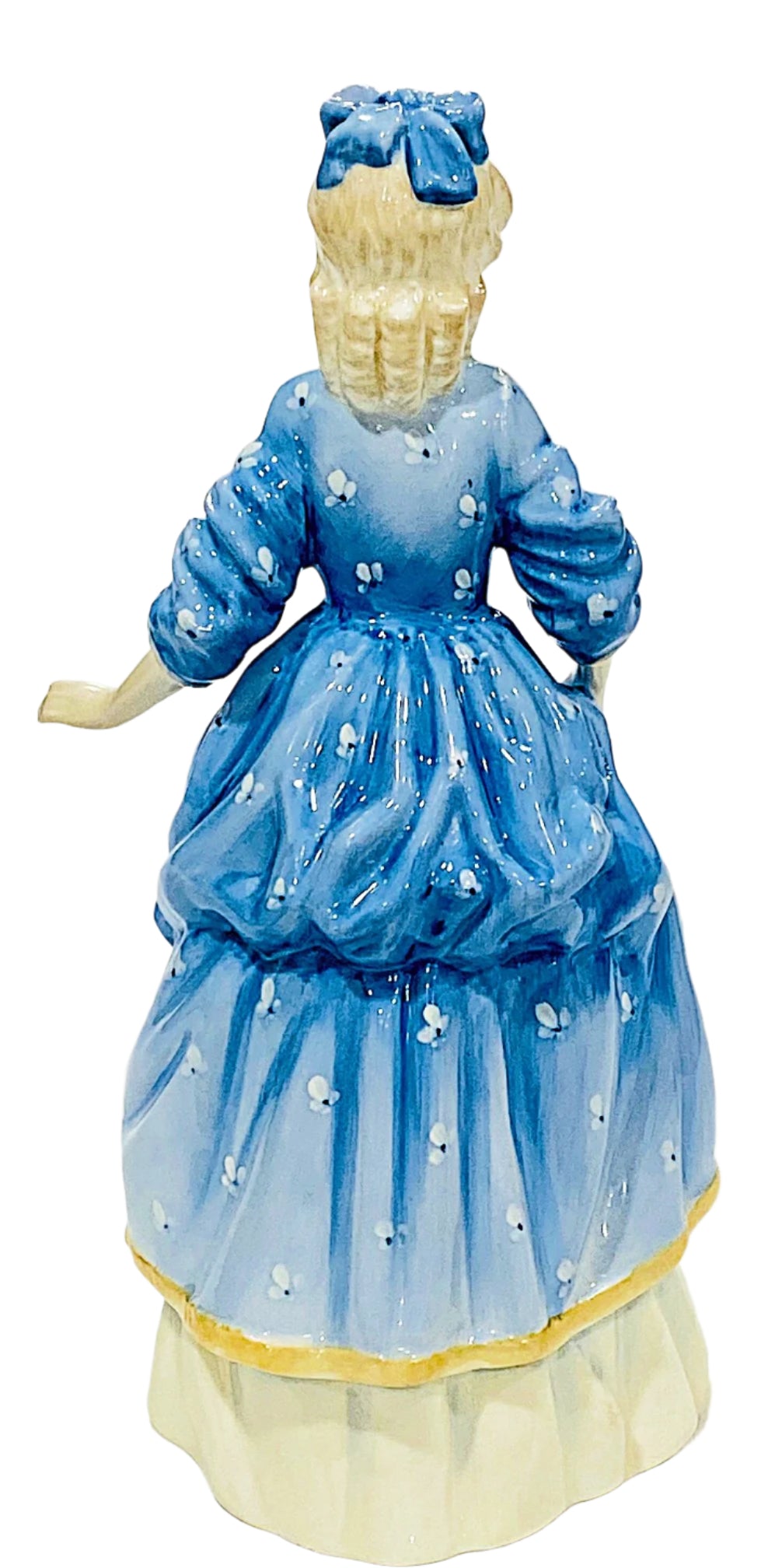 Vintage Bonechina figurine of a woman in a blue dress with a white background