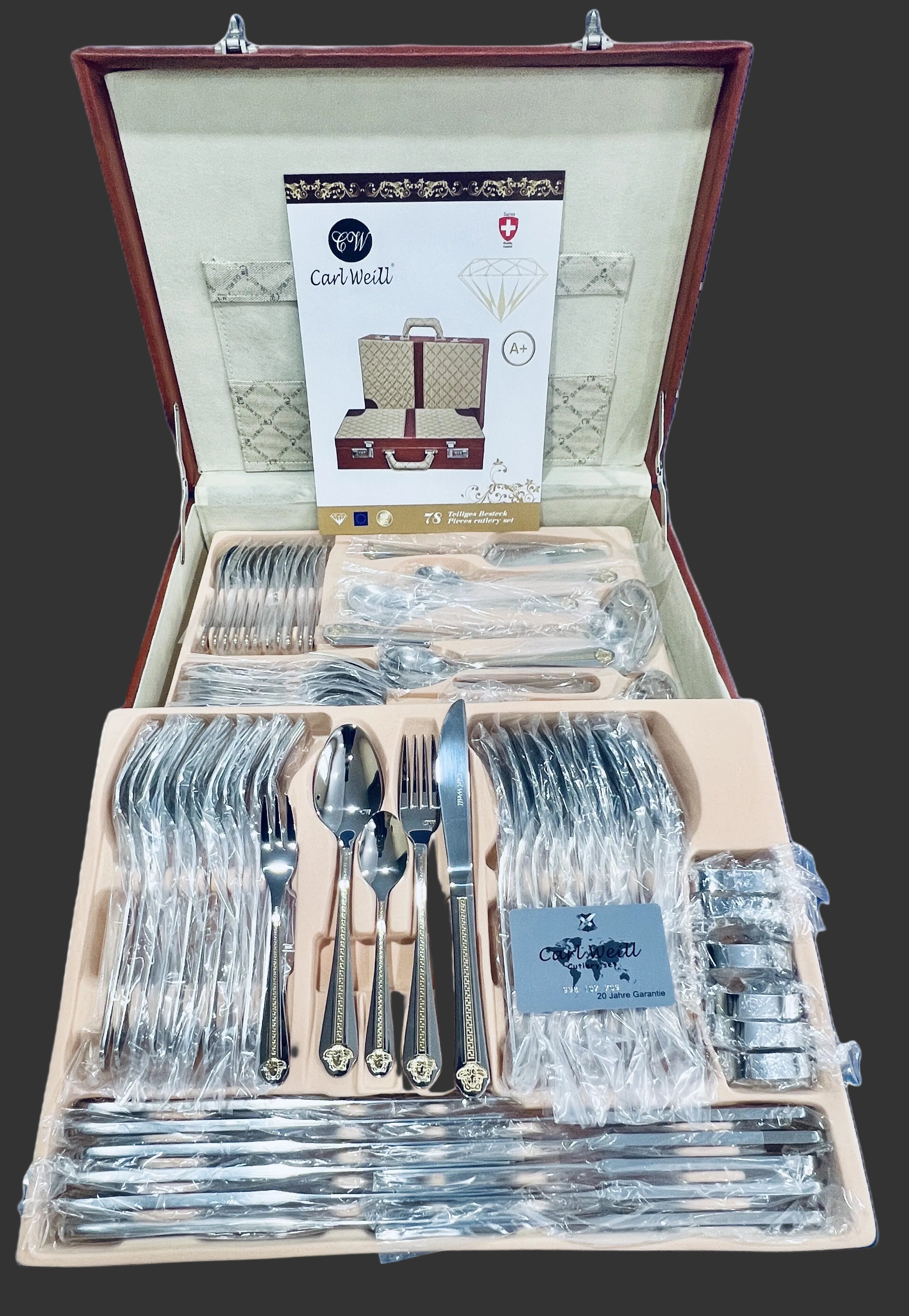 Set of silverware in an open wooden case with a visible brand label.