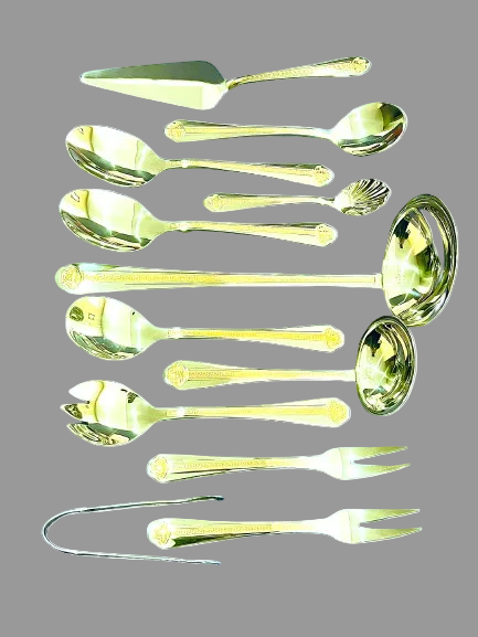Set of gold-colored spoons and ladle on a white background