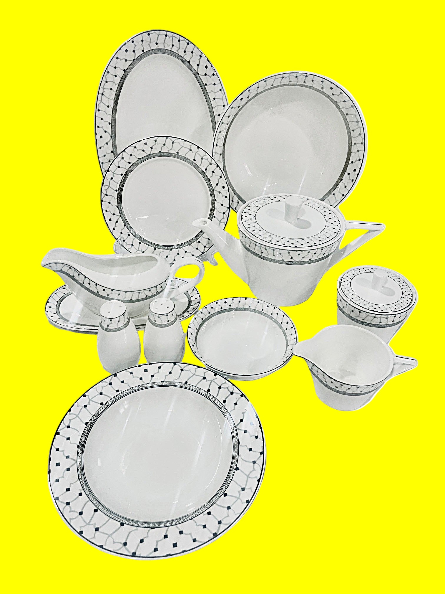 White ceramic dinnerware set with decorative black patterns on a white background