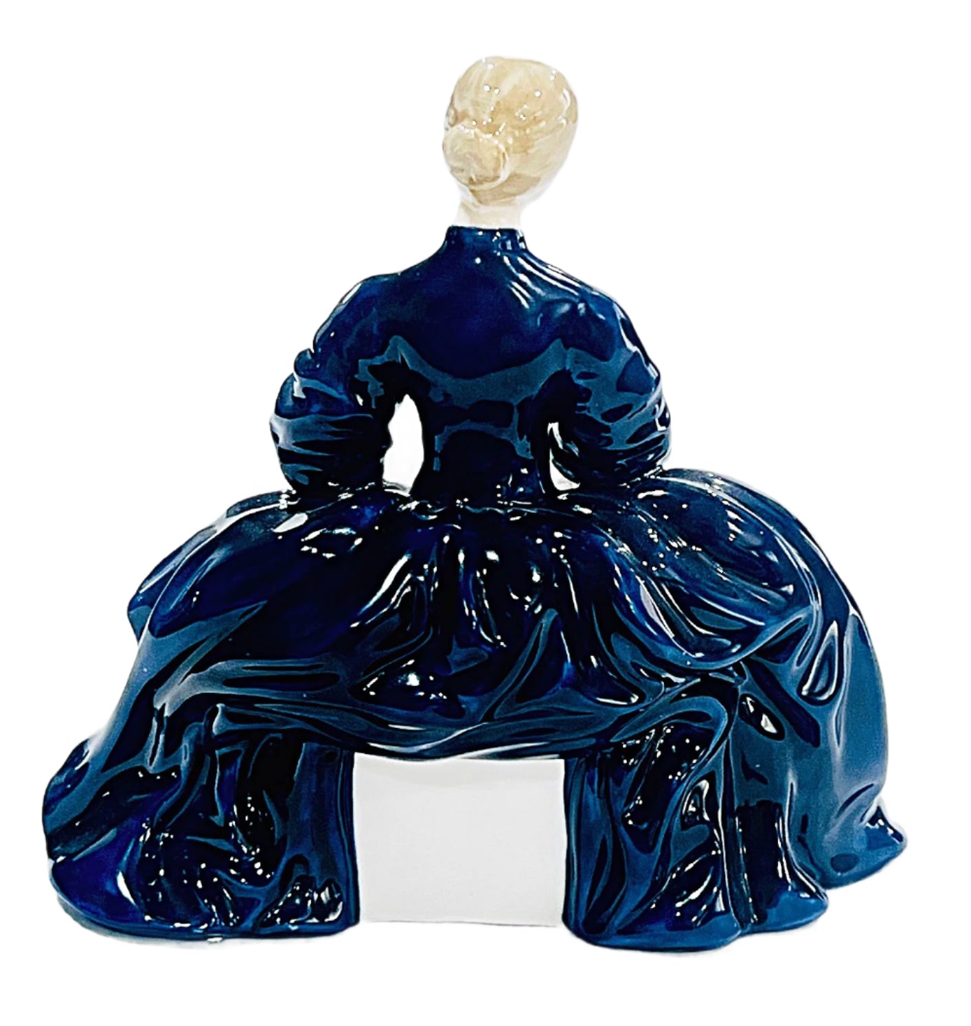 Blue Bone china sculpture of a seated figure with a white head on a light gray background