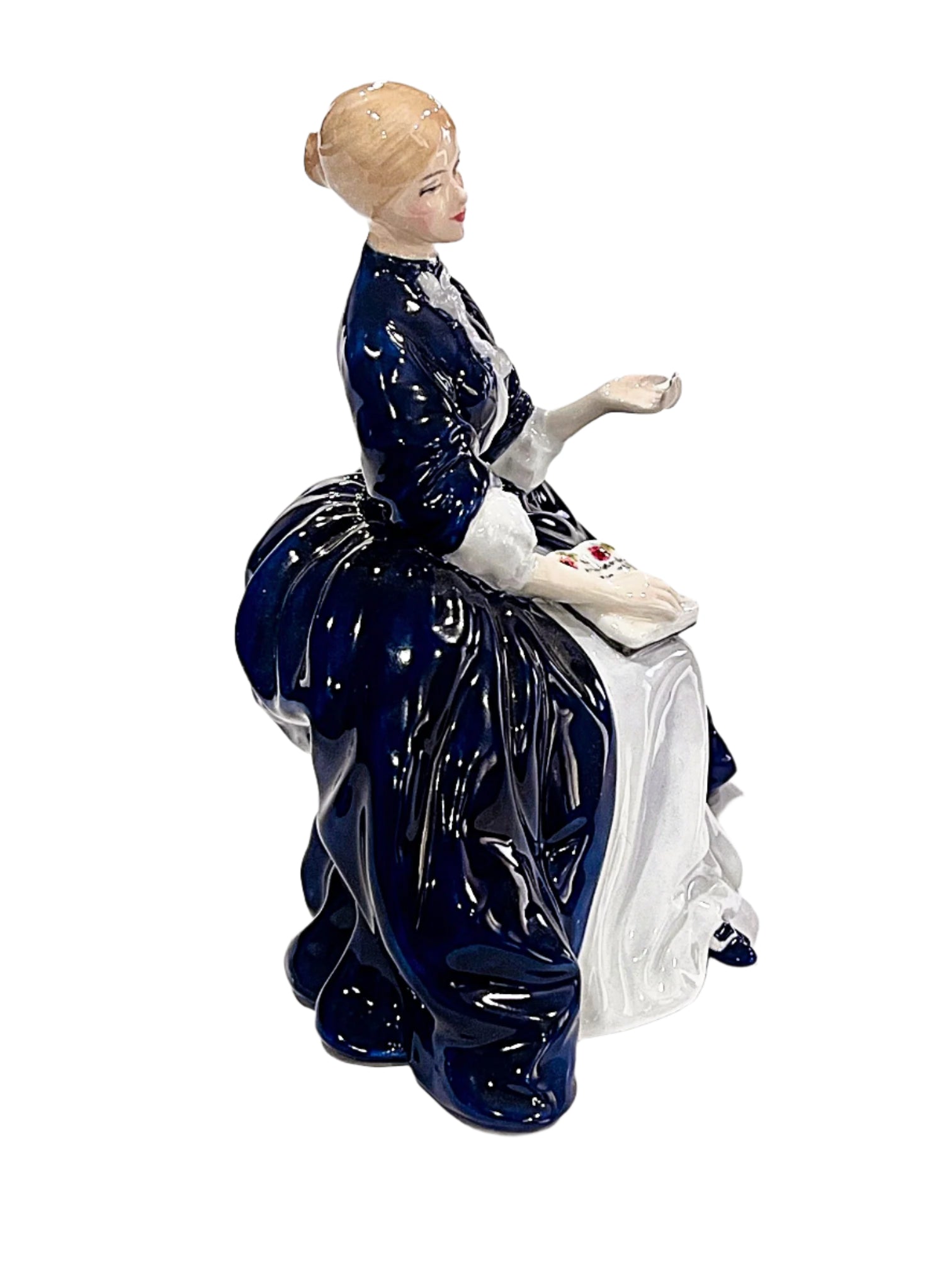 Bone chinaelain figurine of a woman in a blue dress on a white background