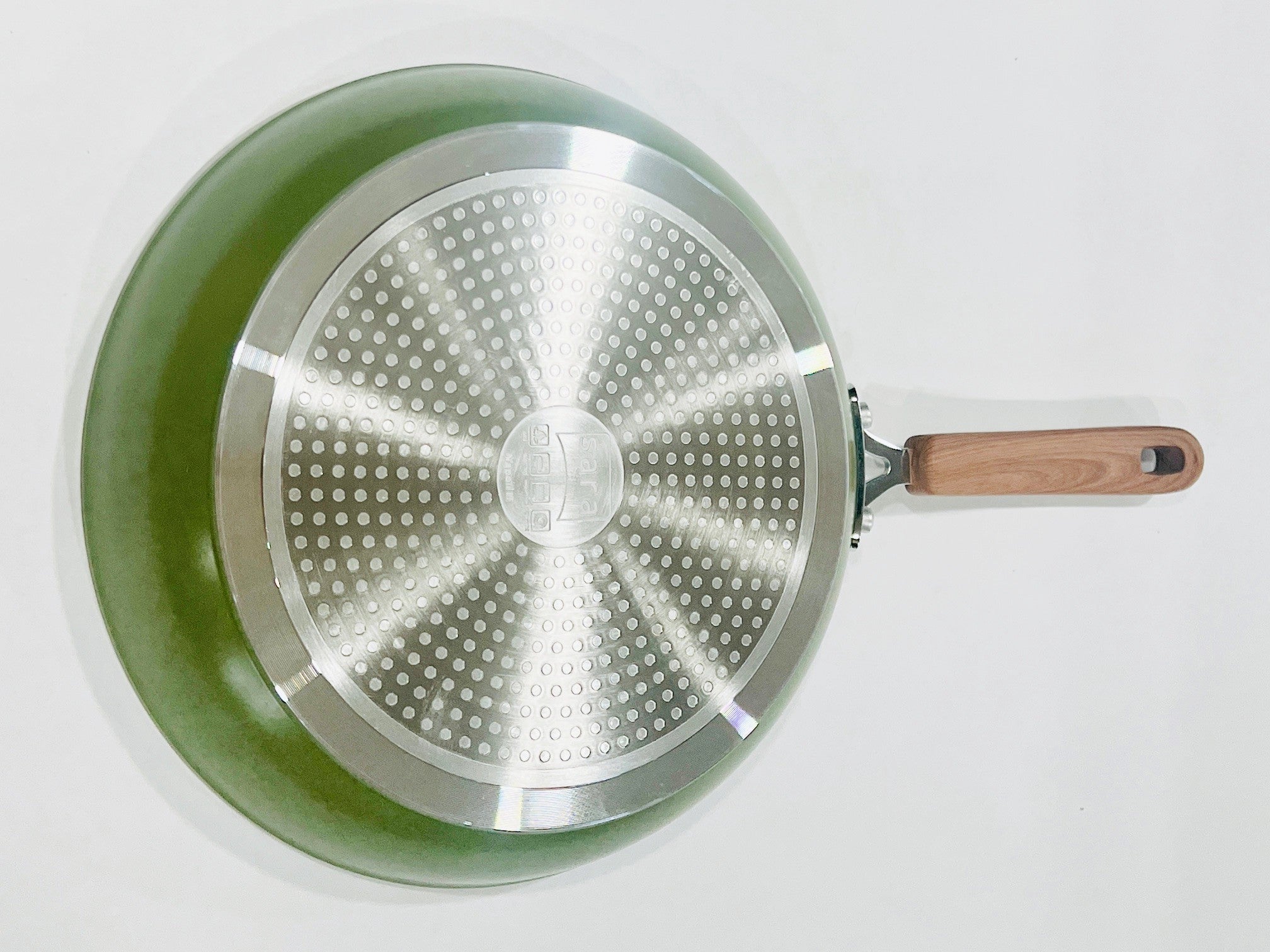 Green frying pan with wooden handle on a white background