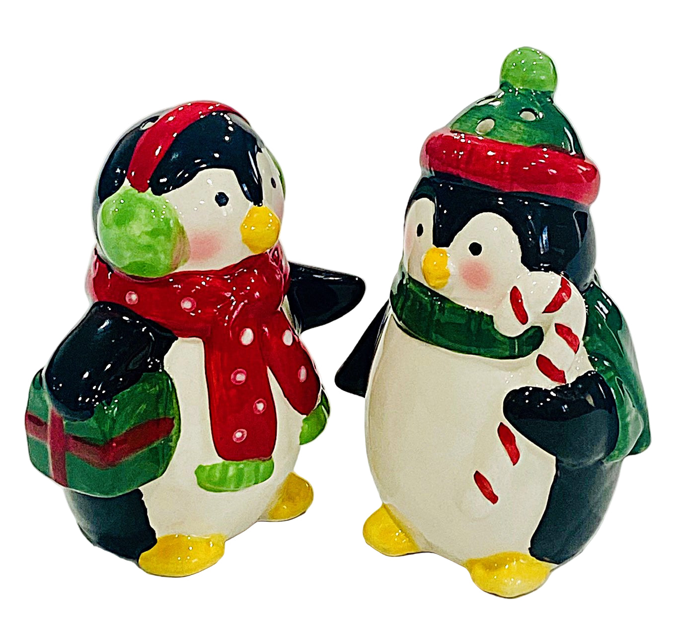 Two penguin salt and pepper figurines wearing winter hats and scarves on a white background
