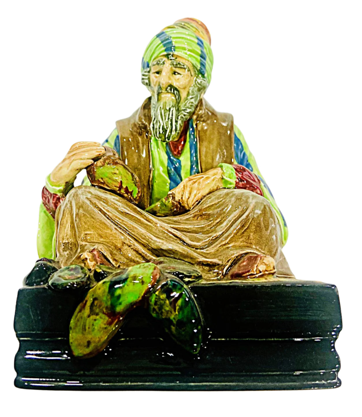 Colorful figurine of a seated figure with a turban on a white background