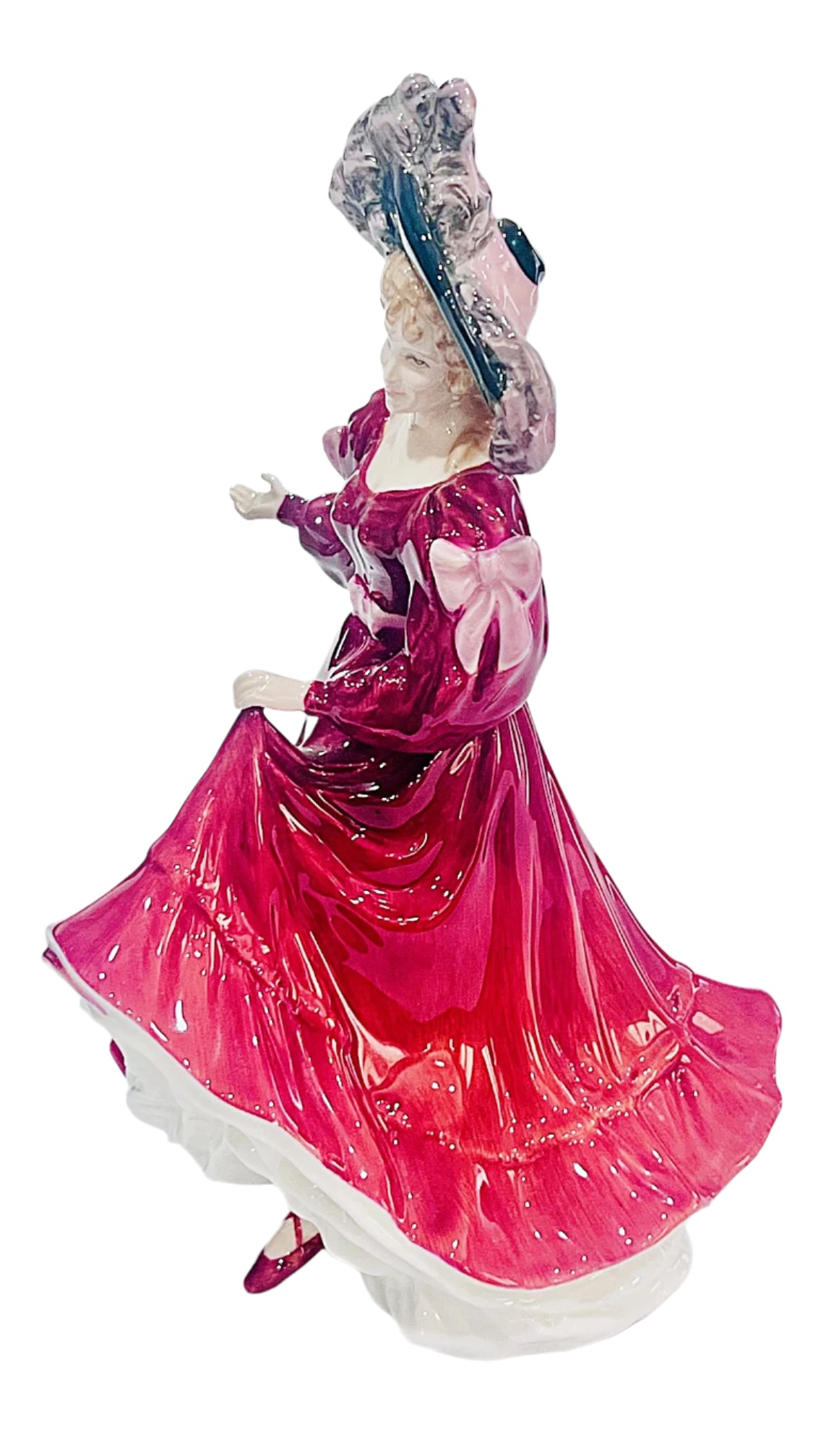 Bone china figurine of a woman in a red dress with a white background