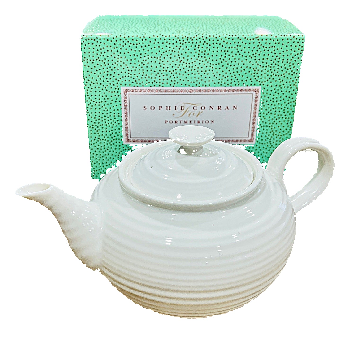 White teapot on a marble surface with a green Sophie Conran for Portmeirion box in the background.