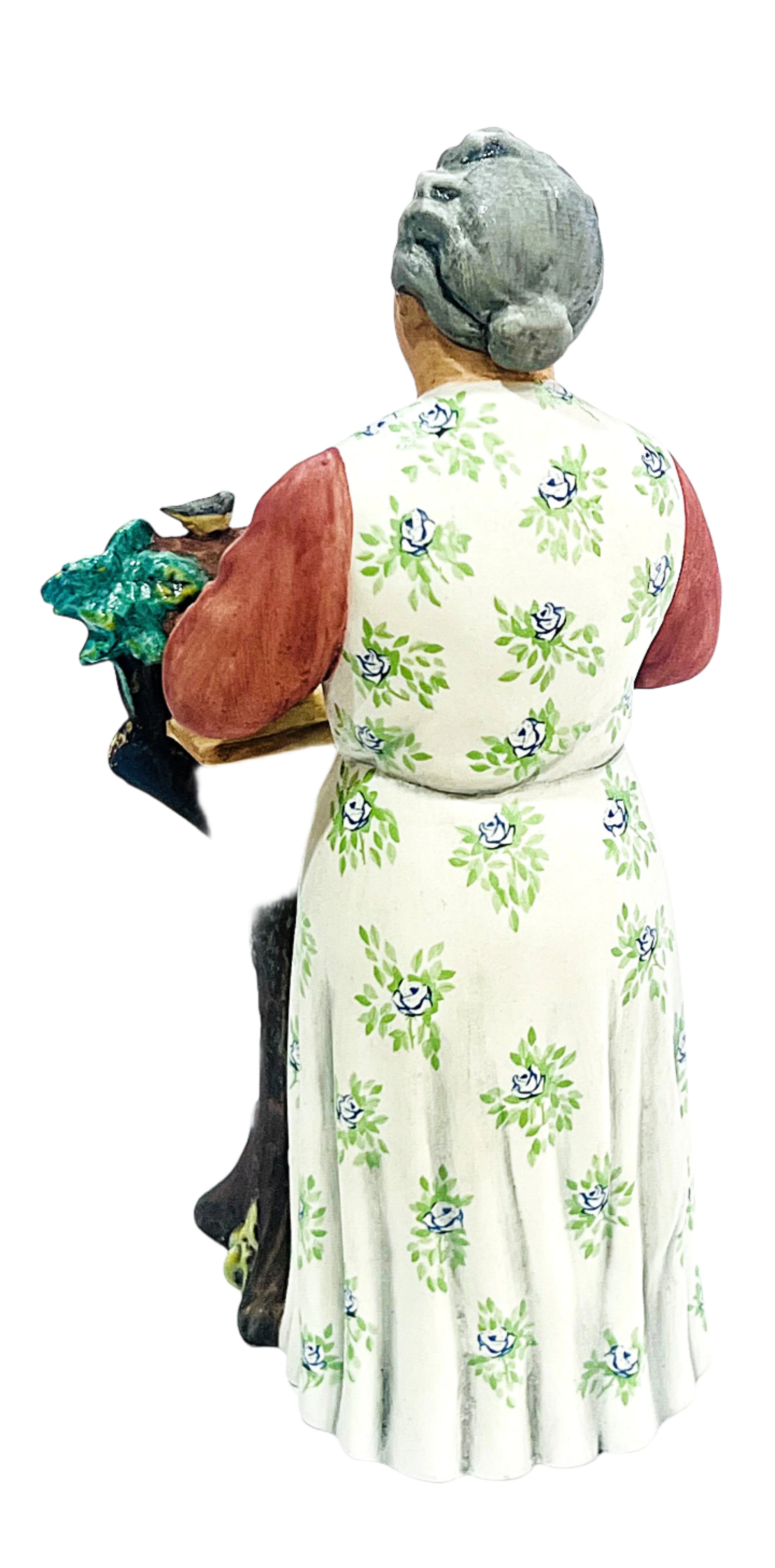 Statue of a woman in a floral dress holding a basket on a white background