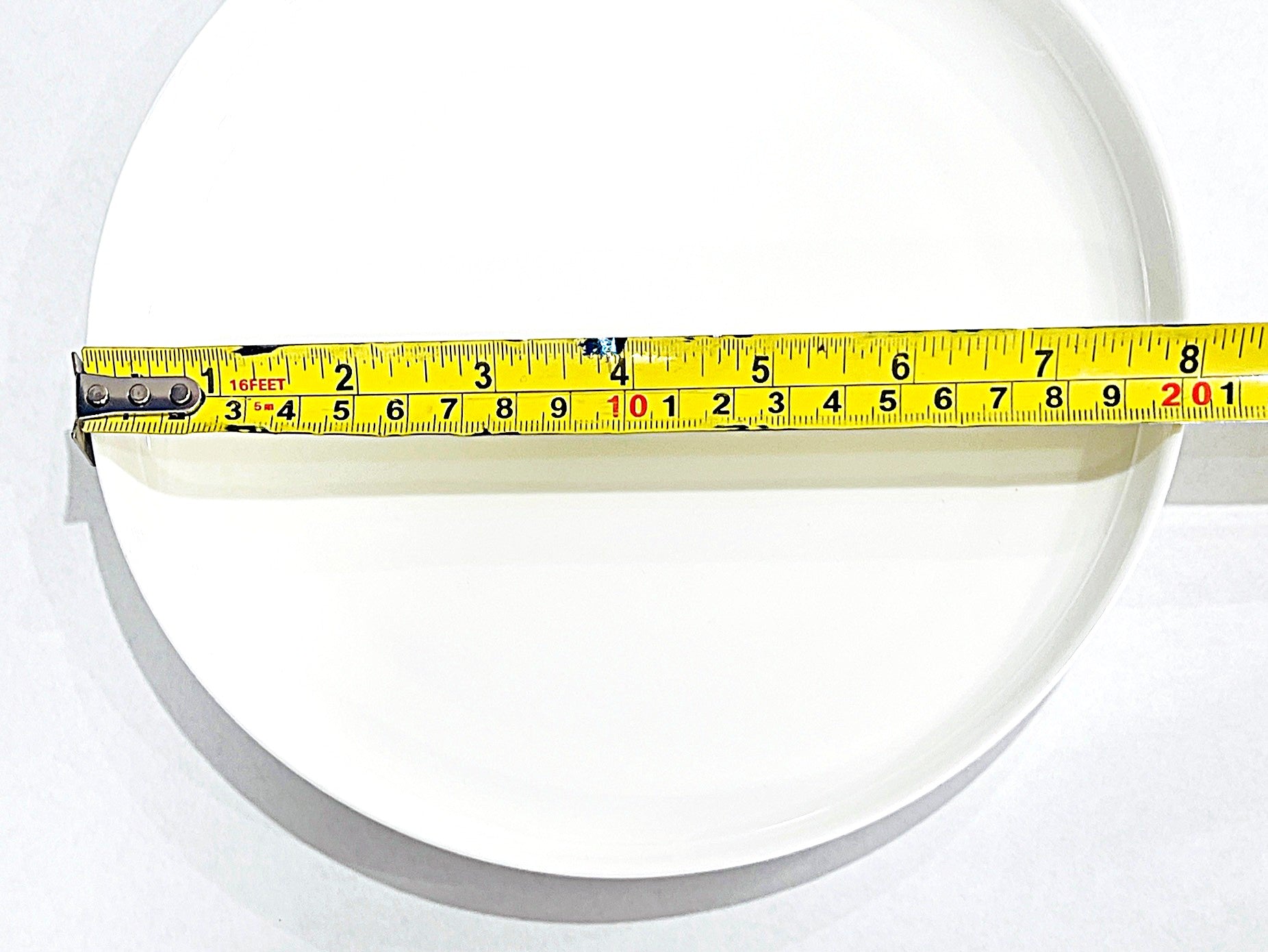 Measuring tape on a white bone china plate circular