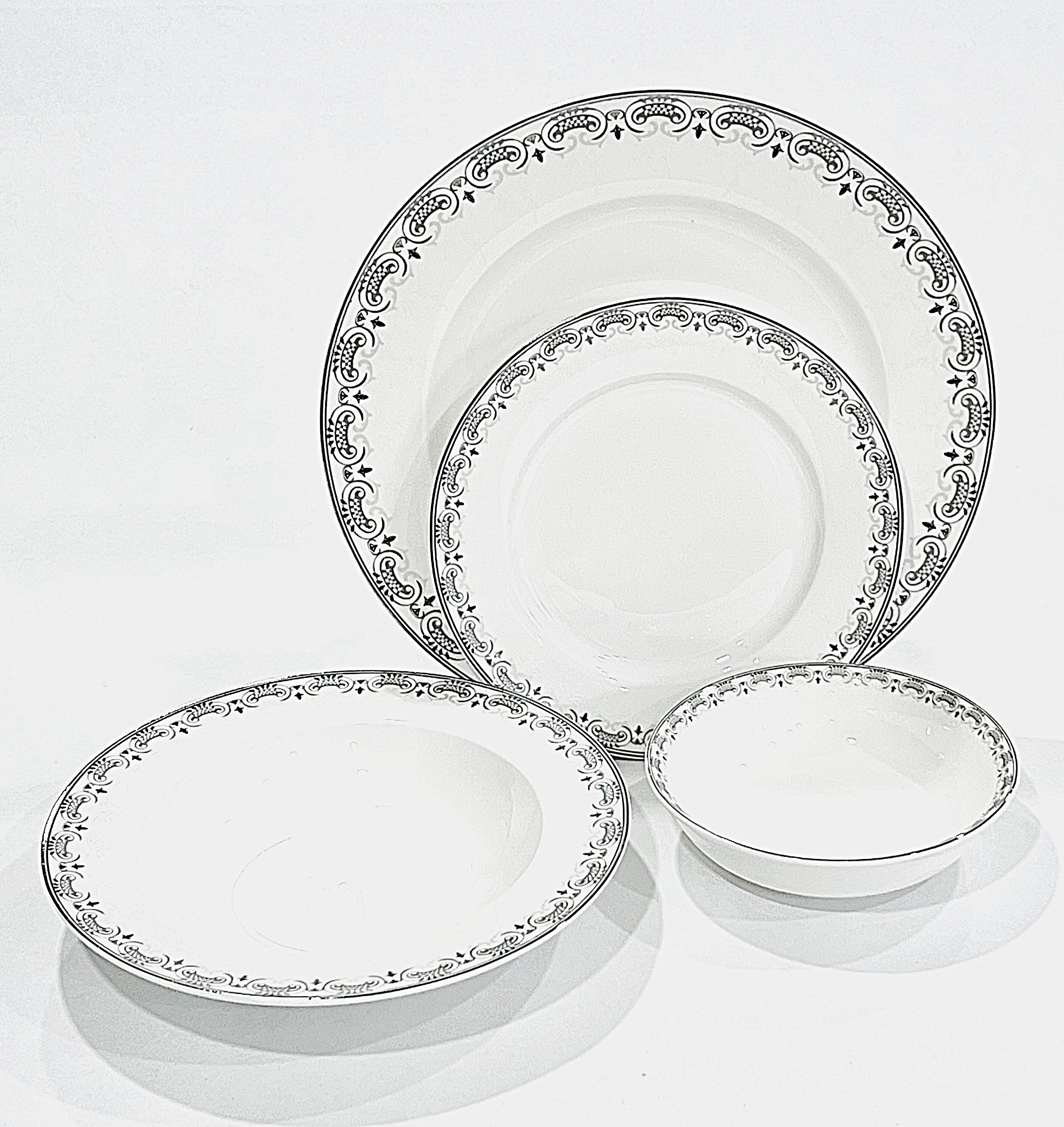 Set of silver-rimmed plates and a bowl on a white background