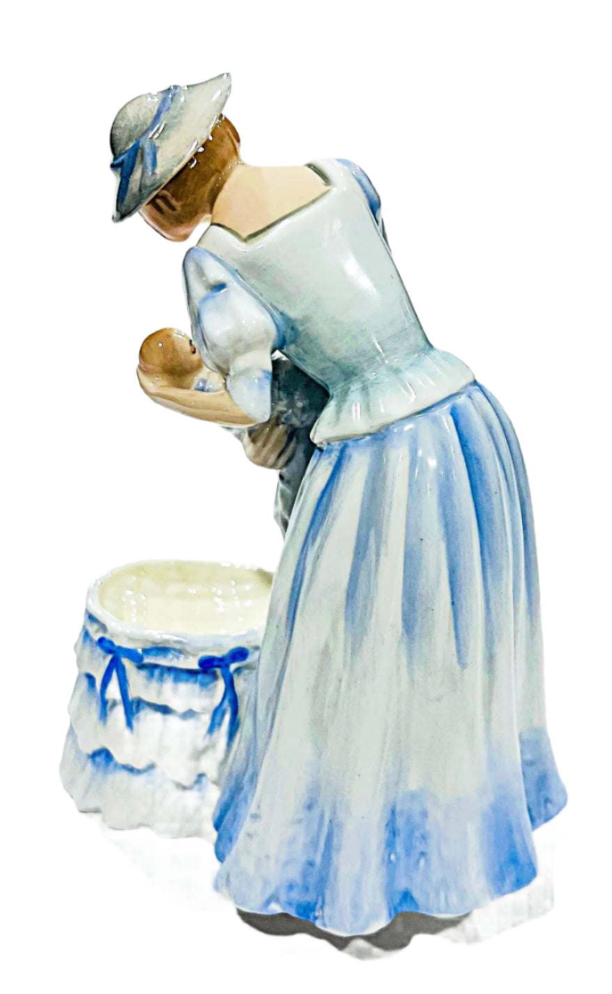 Porcelain figurine of a woman with a baby on a white background