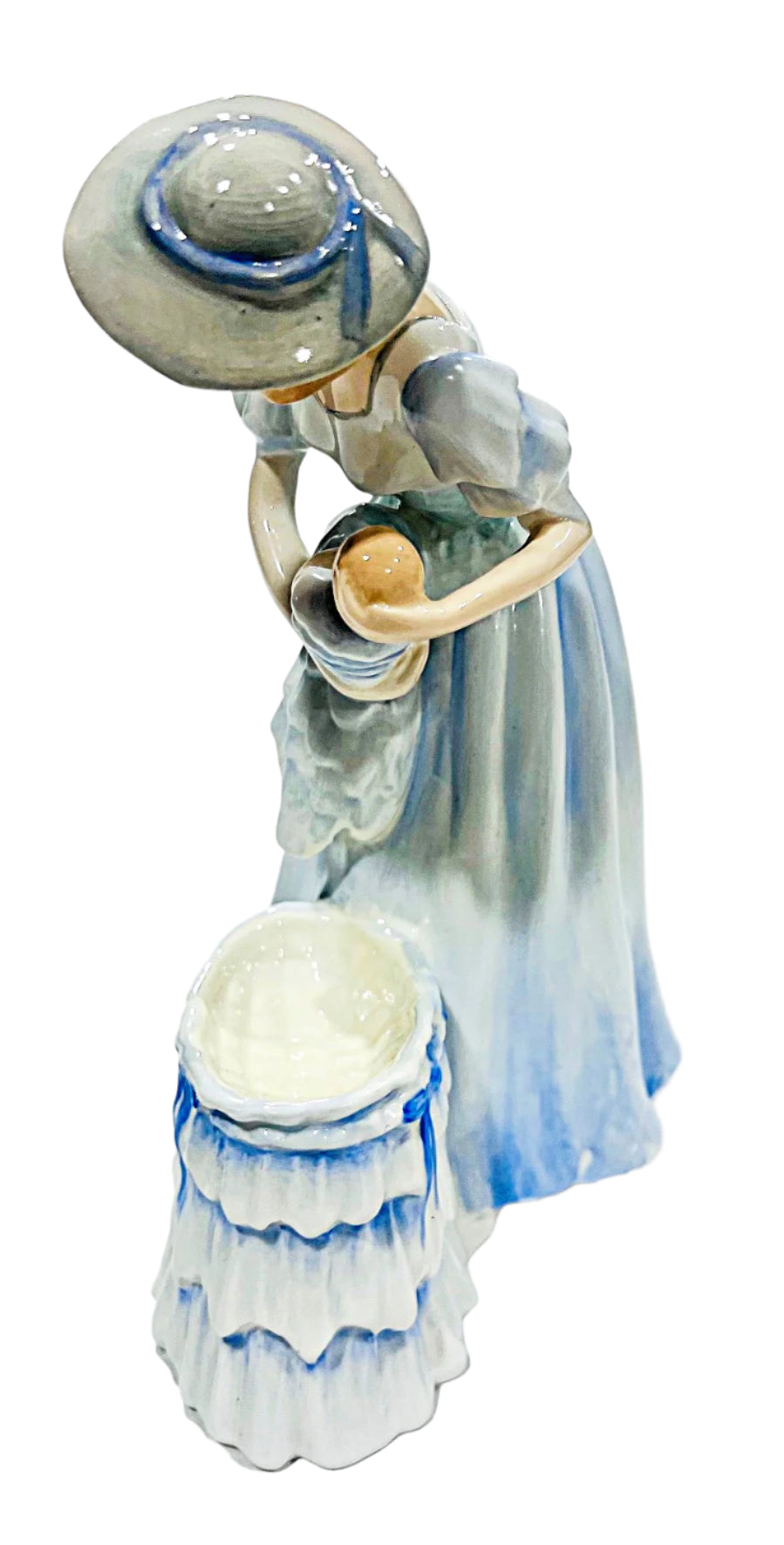 Porcelain figurine of a woman holding a baby on a white background