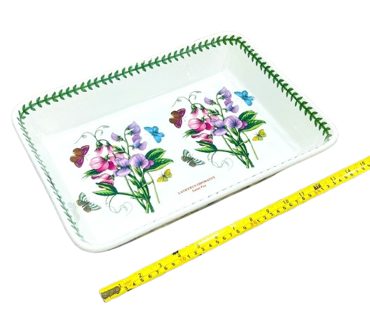 Decorative tray with floral and butterfly design next to a ruler for scale on a white background