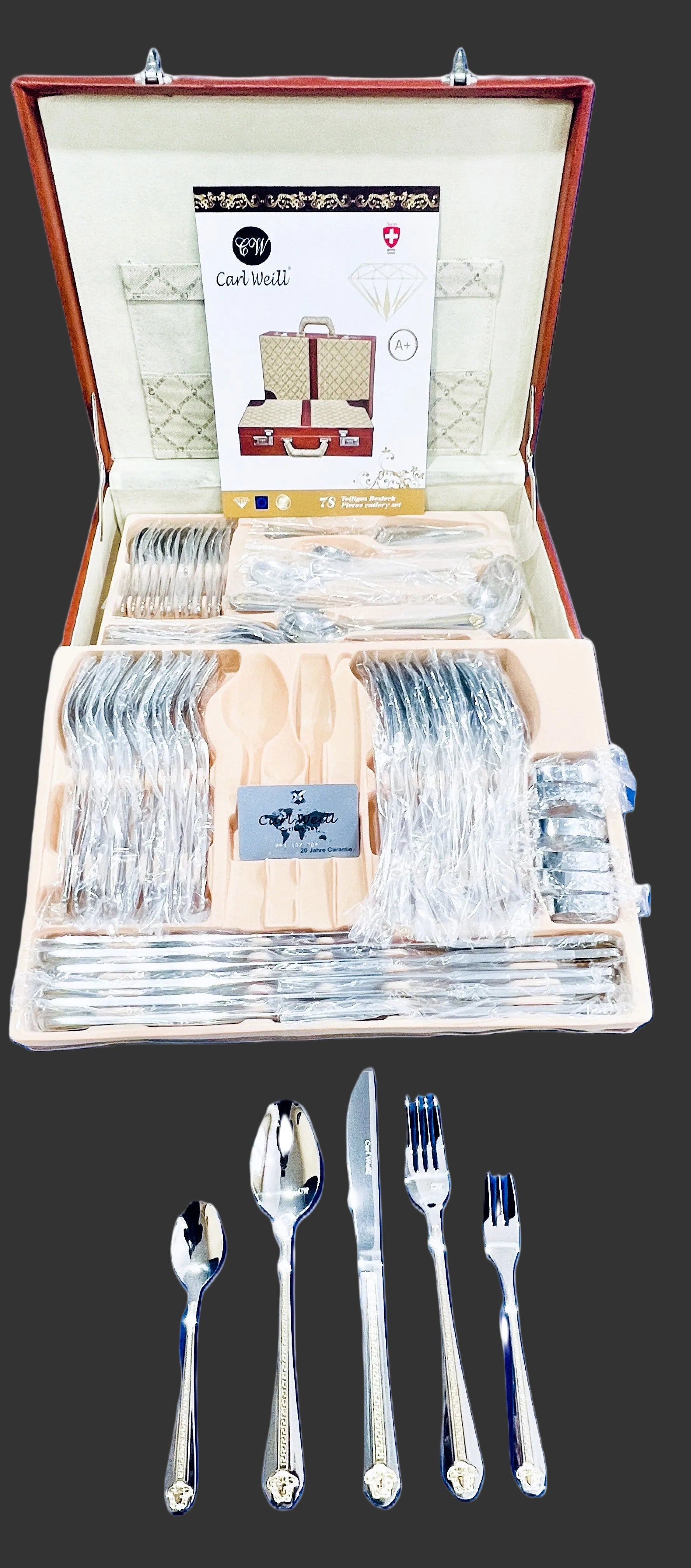 Set of silver cutlery in a wooden case with visible brand labels.