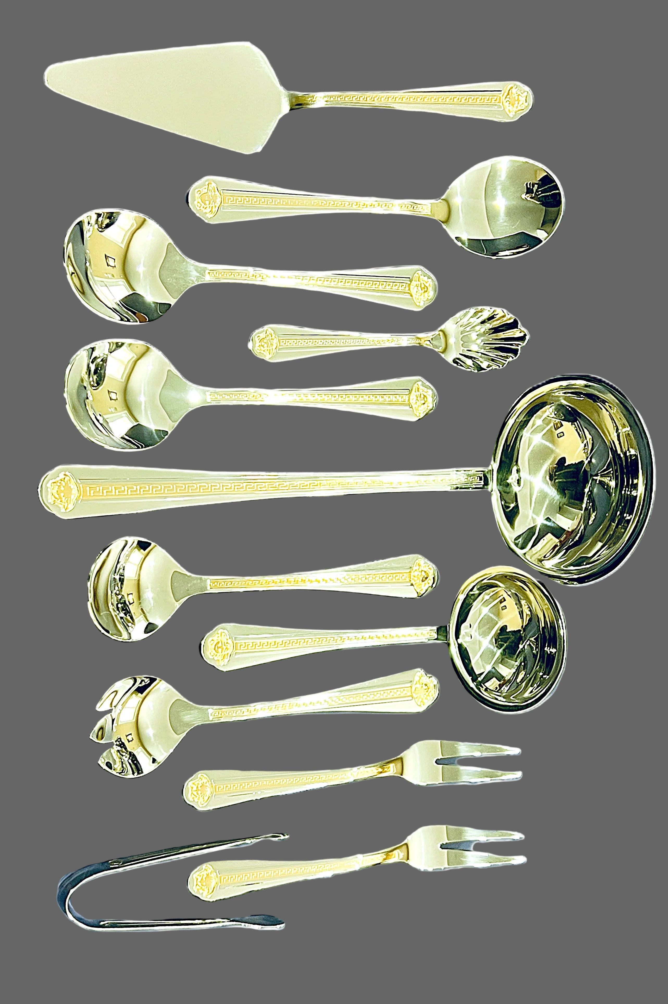 Collection of gold-colored cutlery including spoons, ladles, and a cake server on a white background.