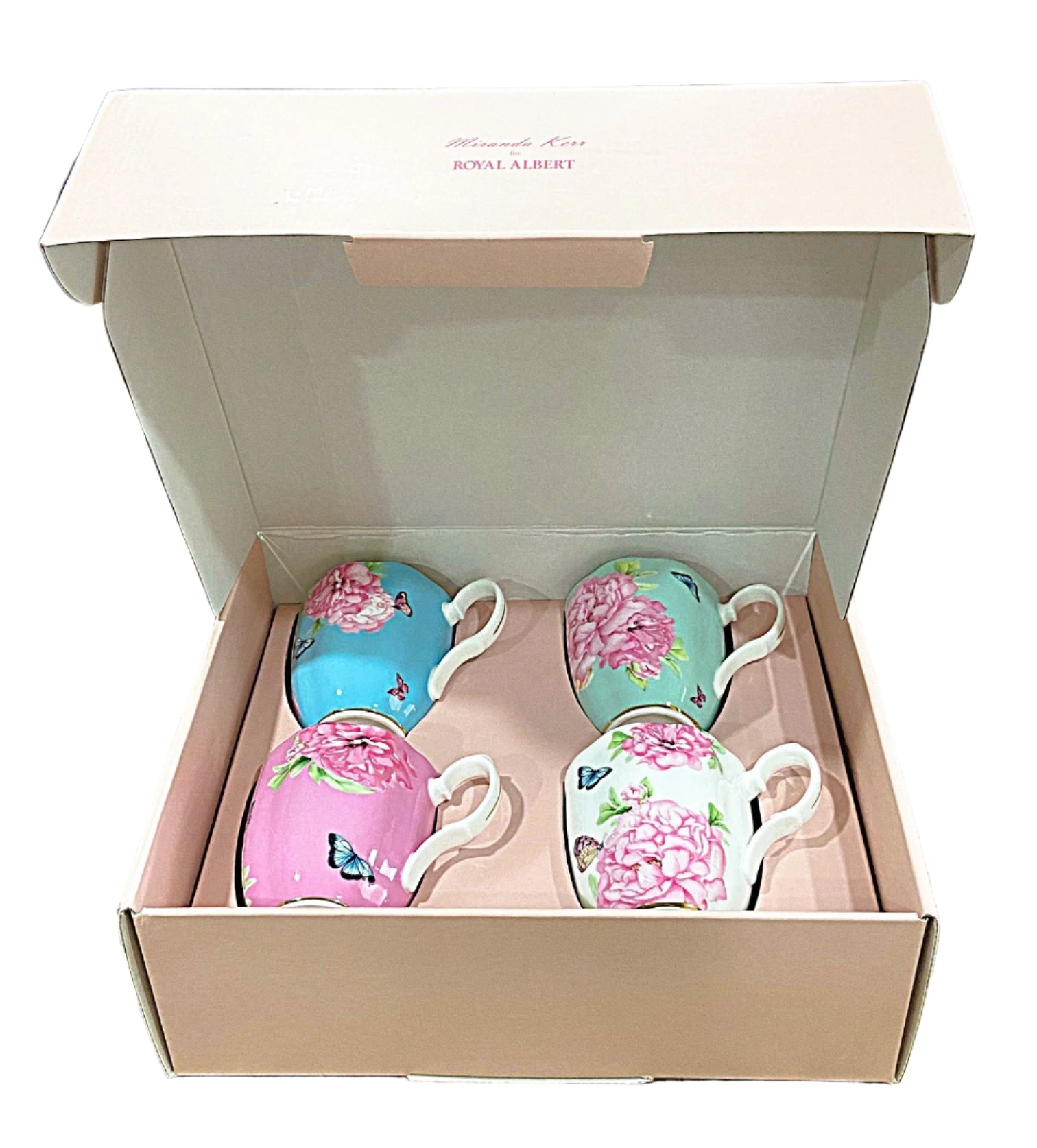 Set of four decorative ceramic cups in a box on a marble surface